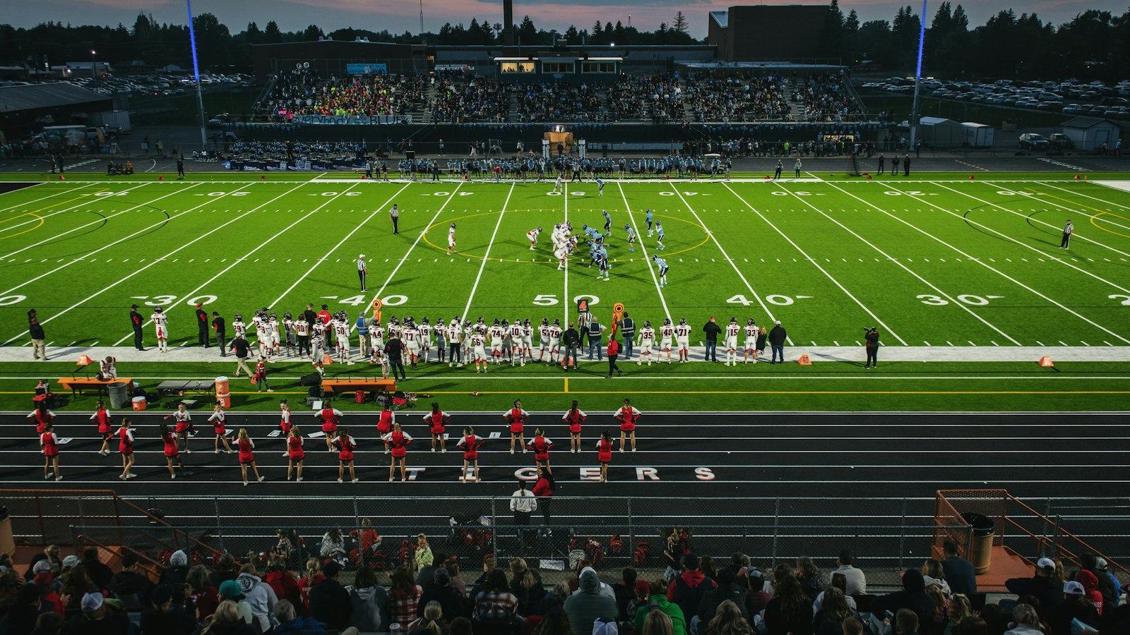 American football field with crowd watching under stadium lights